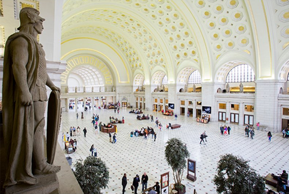 View of a statue overlooking the clean white arched ceilings with gold details in Washington DC's Union Station 