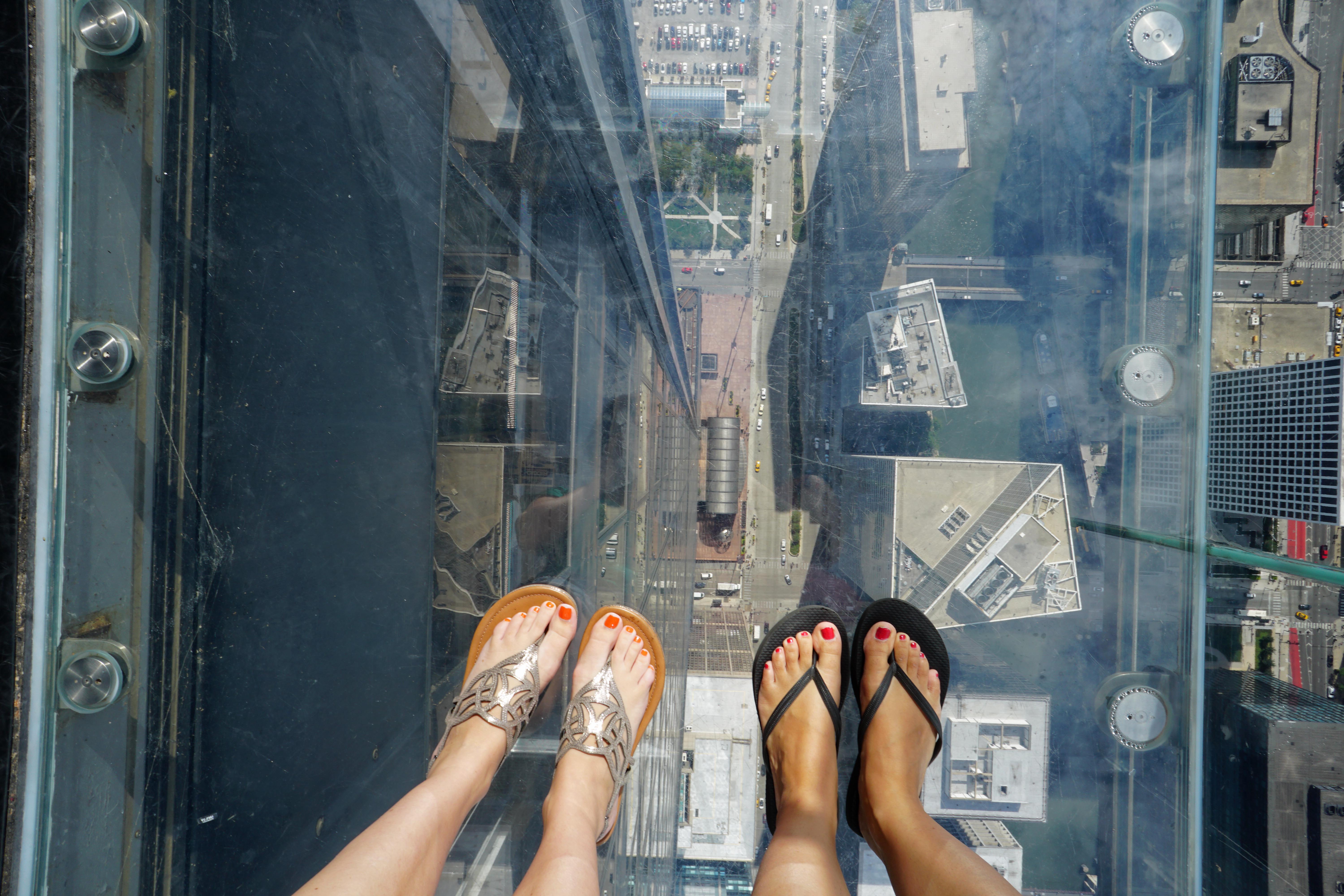 View of our feet looking down through the glass floor of The Ledge 