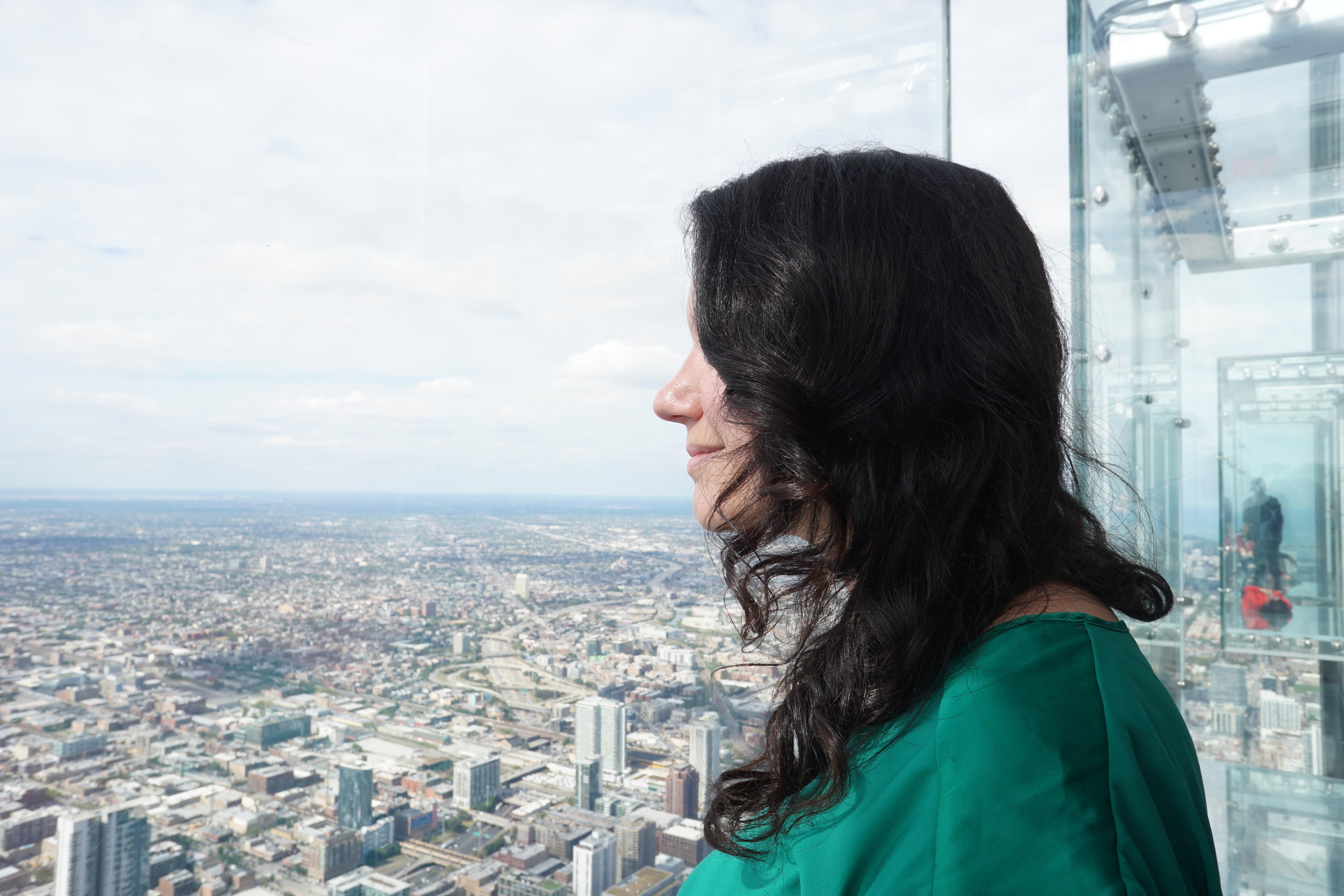 Woman looking out at Skydeck's The Ledge with the other three ledges sticking out of the building behind her