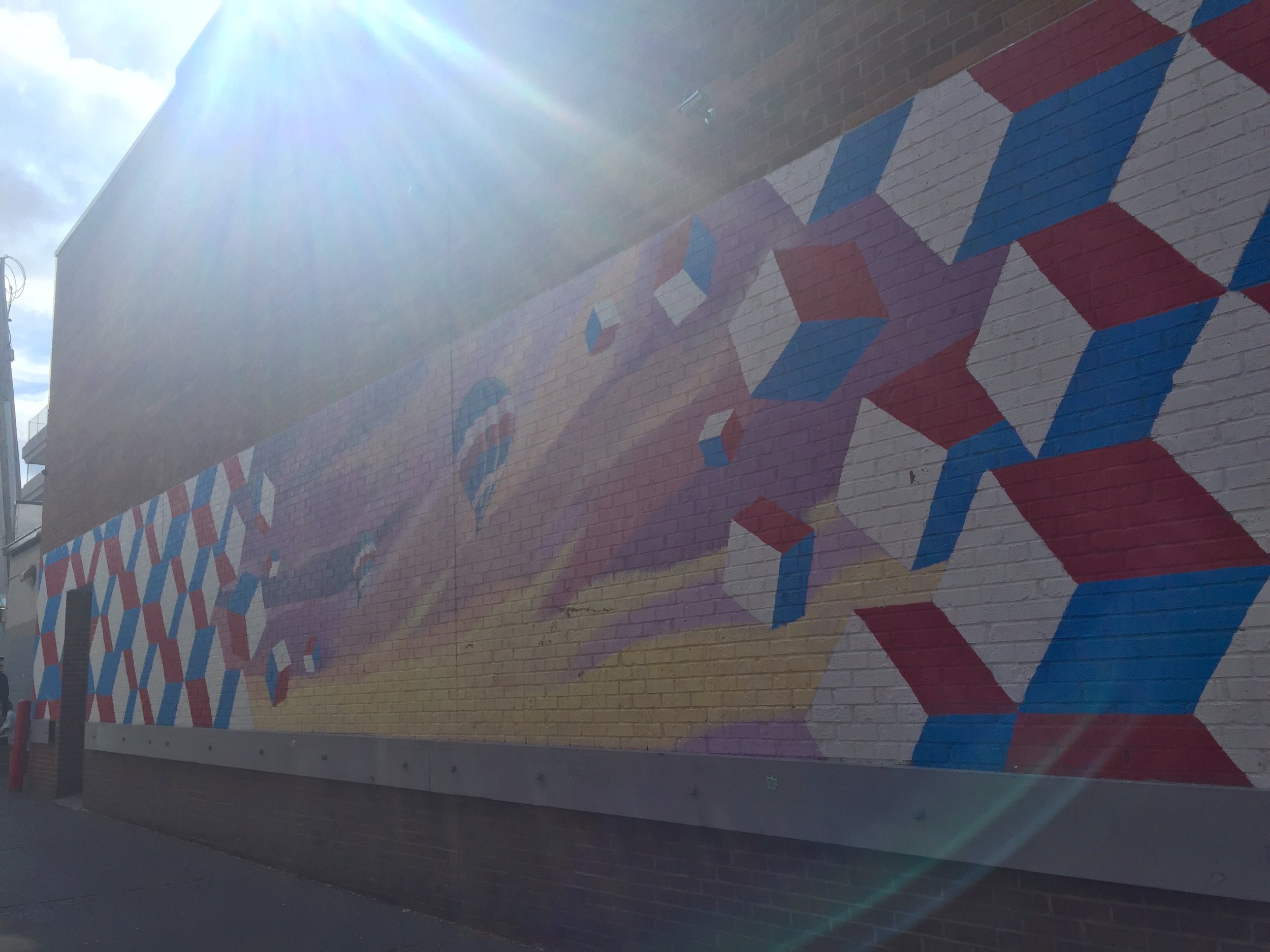2. Balloons: When looking at the Bookstore Mural it is easy to miss this mural down the alley just to the right. It depicts hot air balloons rising through a geometric design. Add a little sun flare and the shot is just golden.