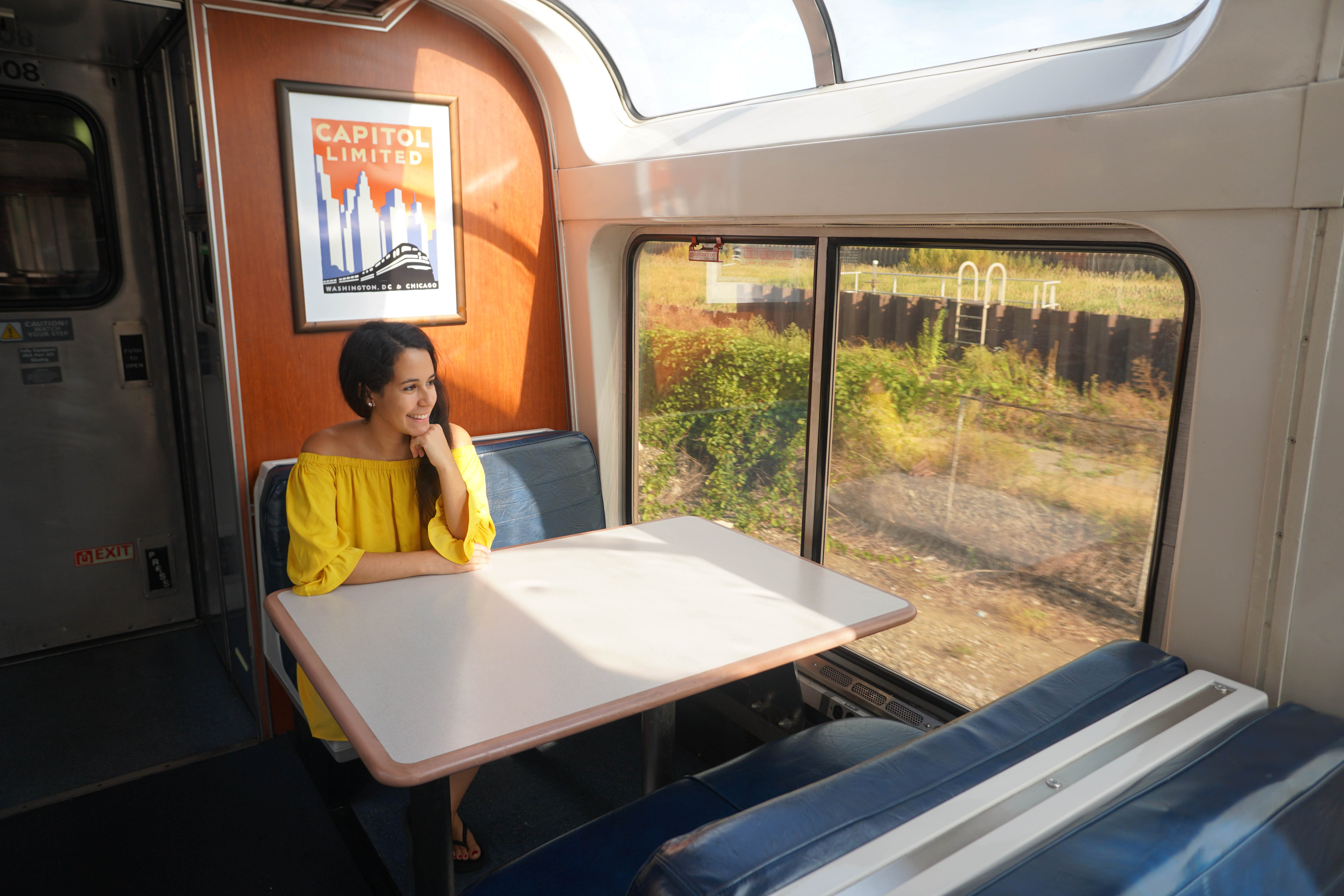 Capitol Limited poster at table with woman looking out window